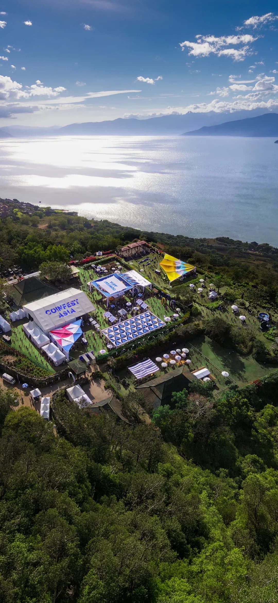 Coinfest Asia main stage, with a gold-hooded figure and red lasers across the dome